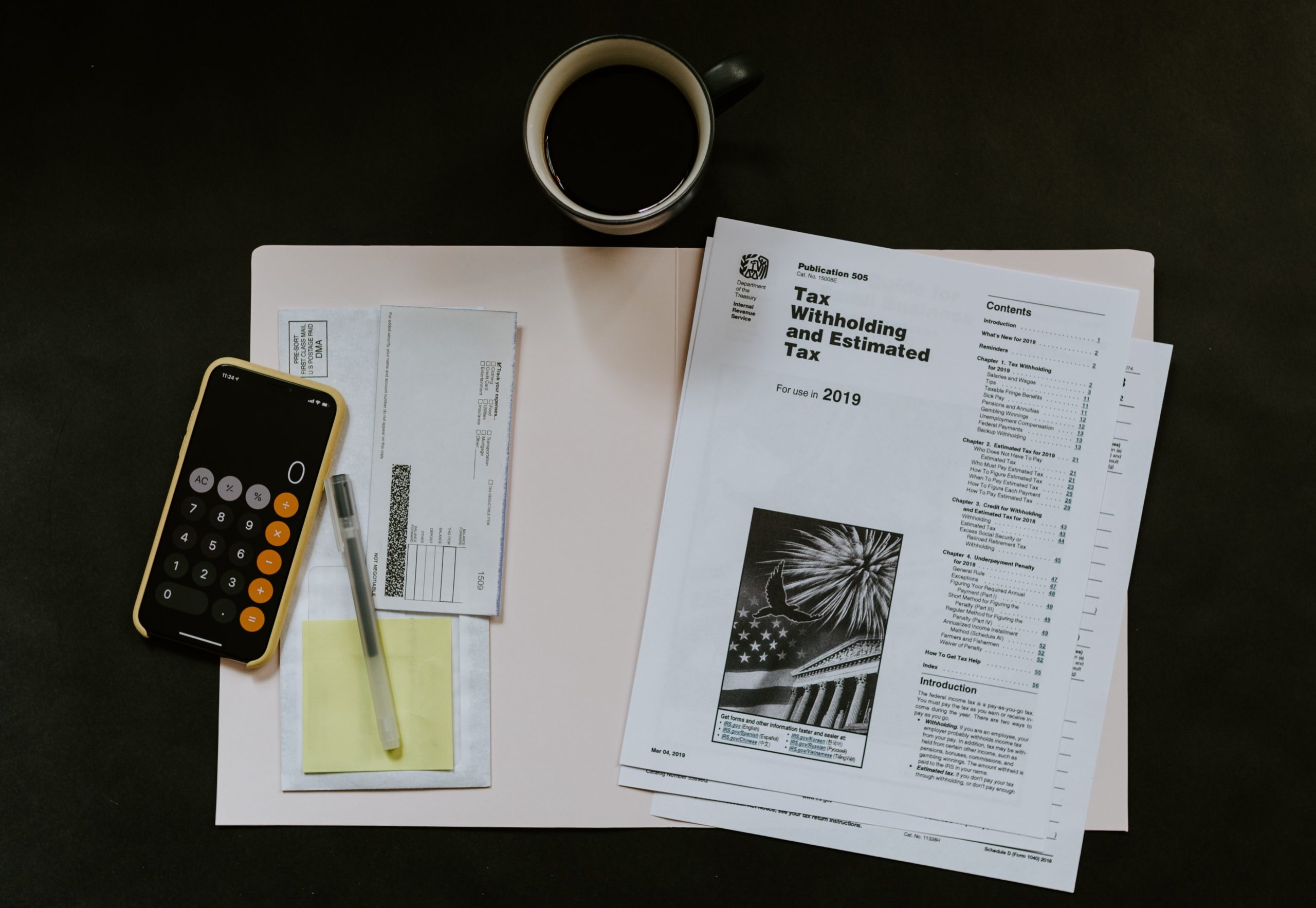 tax paperwork on a table with calculator and coffee