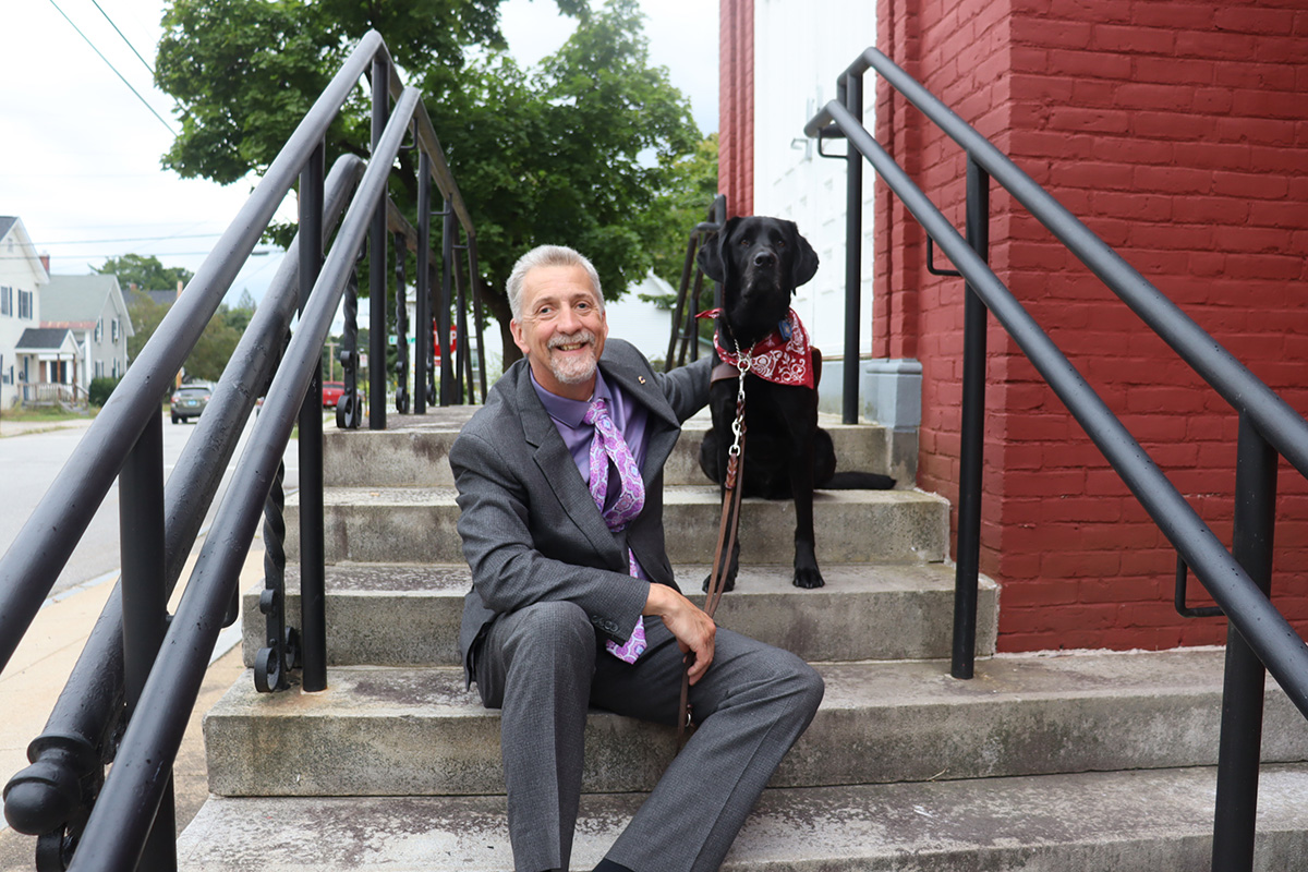 Randy Pierce and his dog Swirl sitting on a stoop