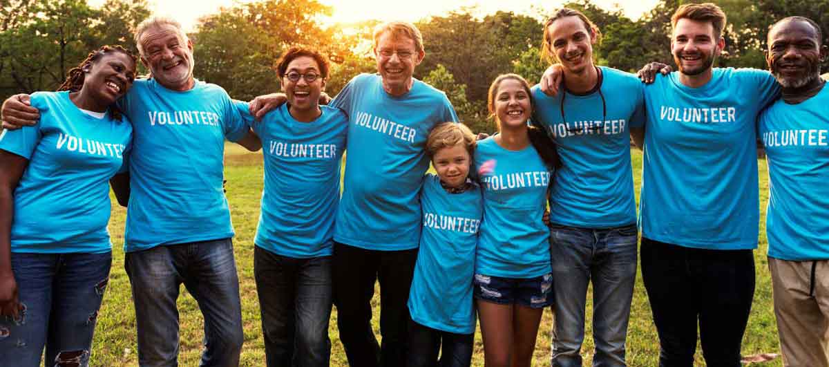 volunteers stand smiling with their arms around each other