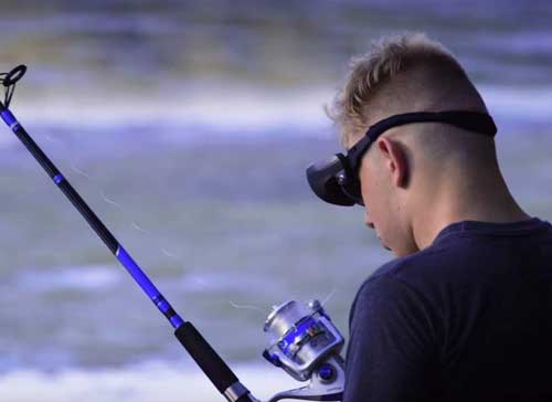 a visually impaired man using special eyewear to fish
