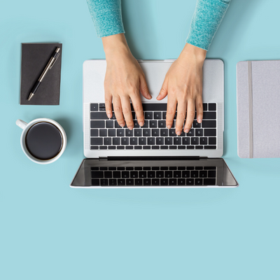 Hands typing on a laptop computer.