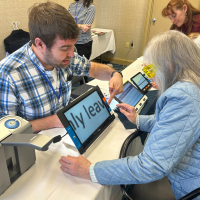 a staff member helps a Silver Retreat participant with technology