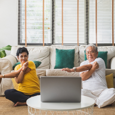 two older individuals stretch their arms