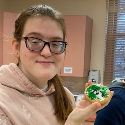 a girl holding a cookie she made