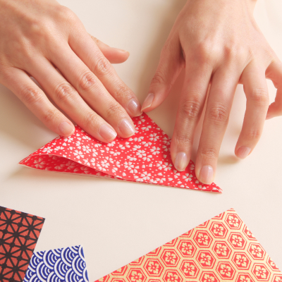 hands folding paper into origami