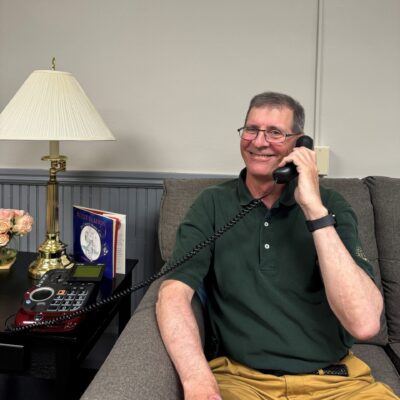 A man uses a TEAP phone while sitting comfortably on a couch.