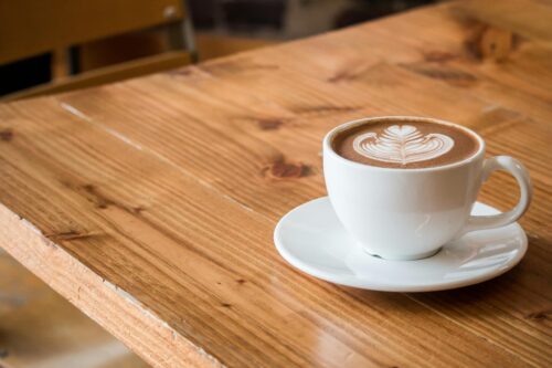 A latte on a wooden counter.