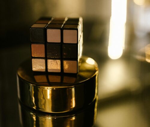 A puzzle cube on a golden stand with green lighting.