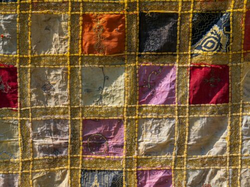 A colorful quilt with intricate embroidery.