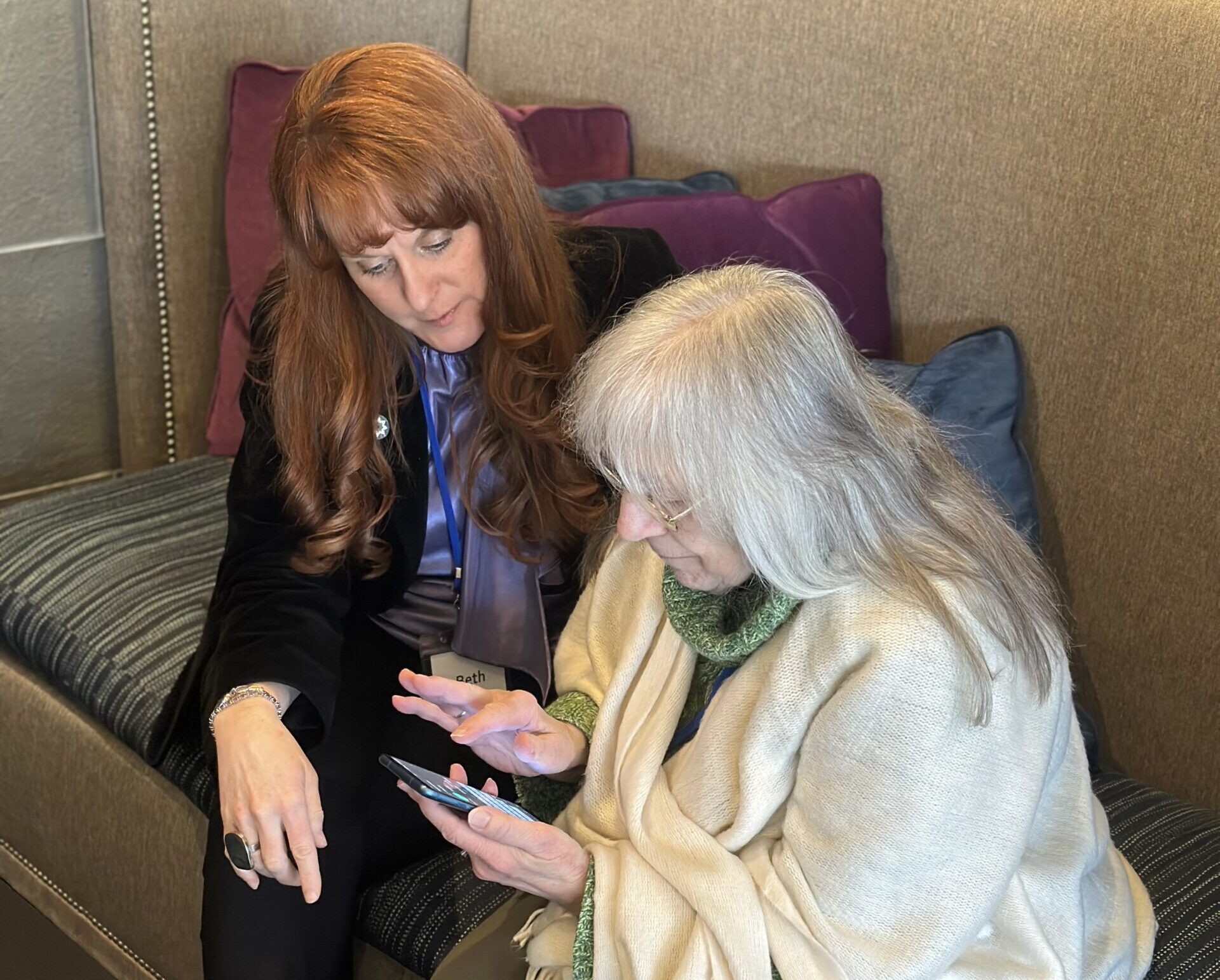 A woman with Future In Sight sits and speaks with a senior woman on a couch.