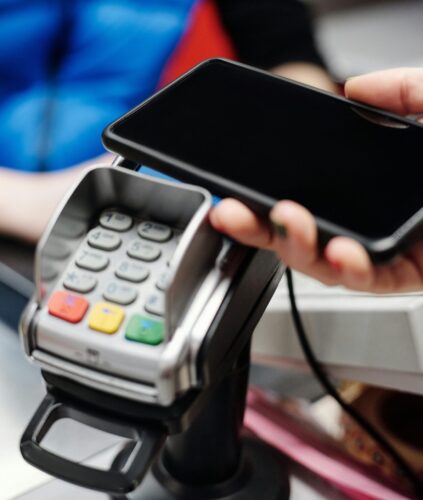 A phone being used with a keypad to pay at a register.