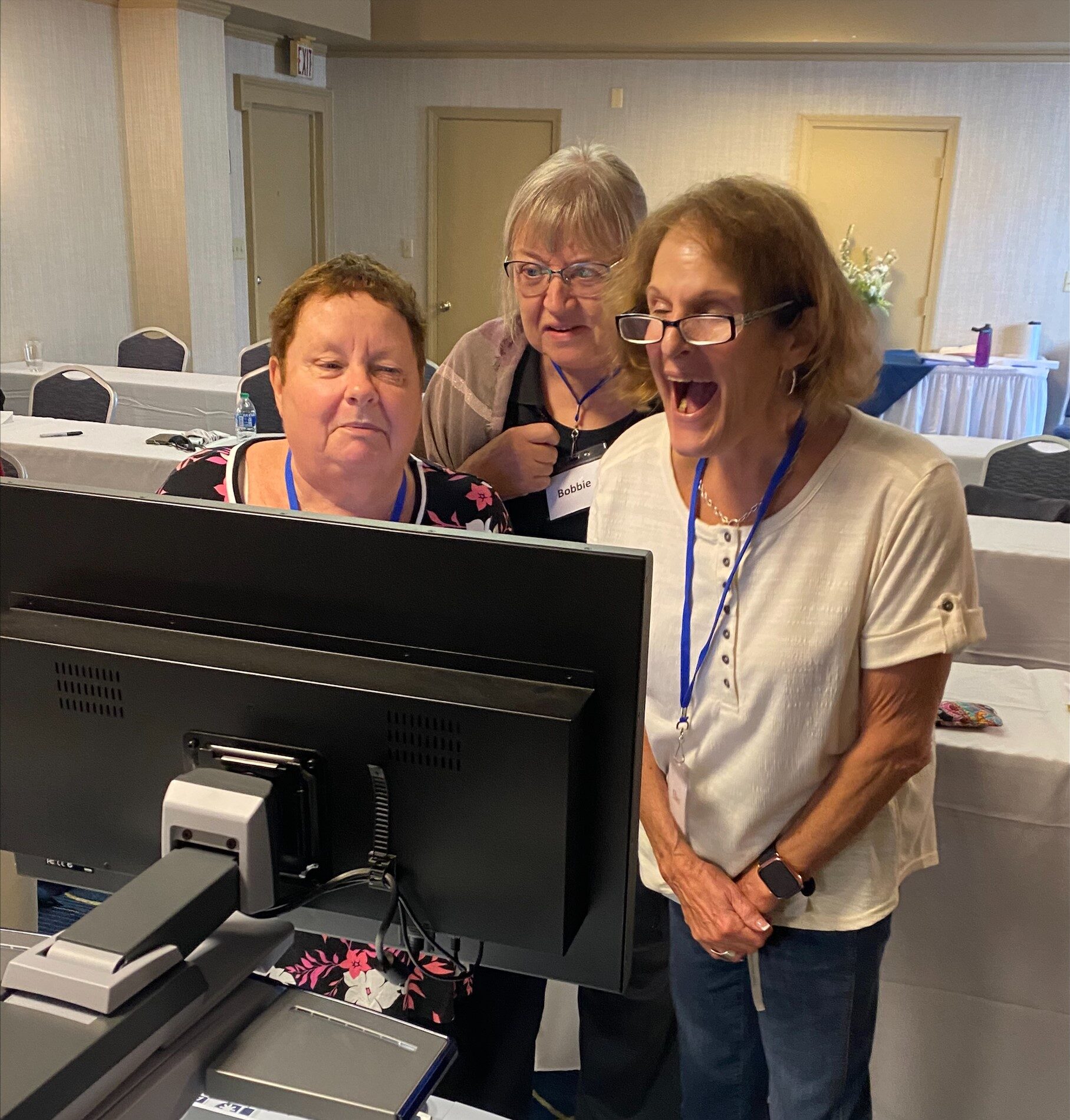 Three senior women excitedly learn how to use a CCTV.