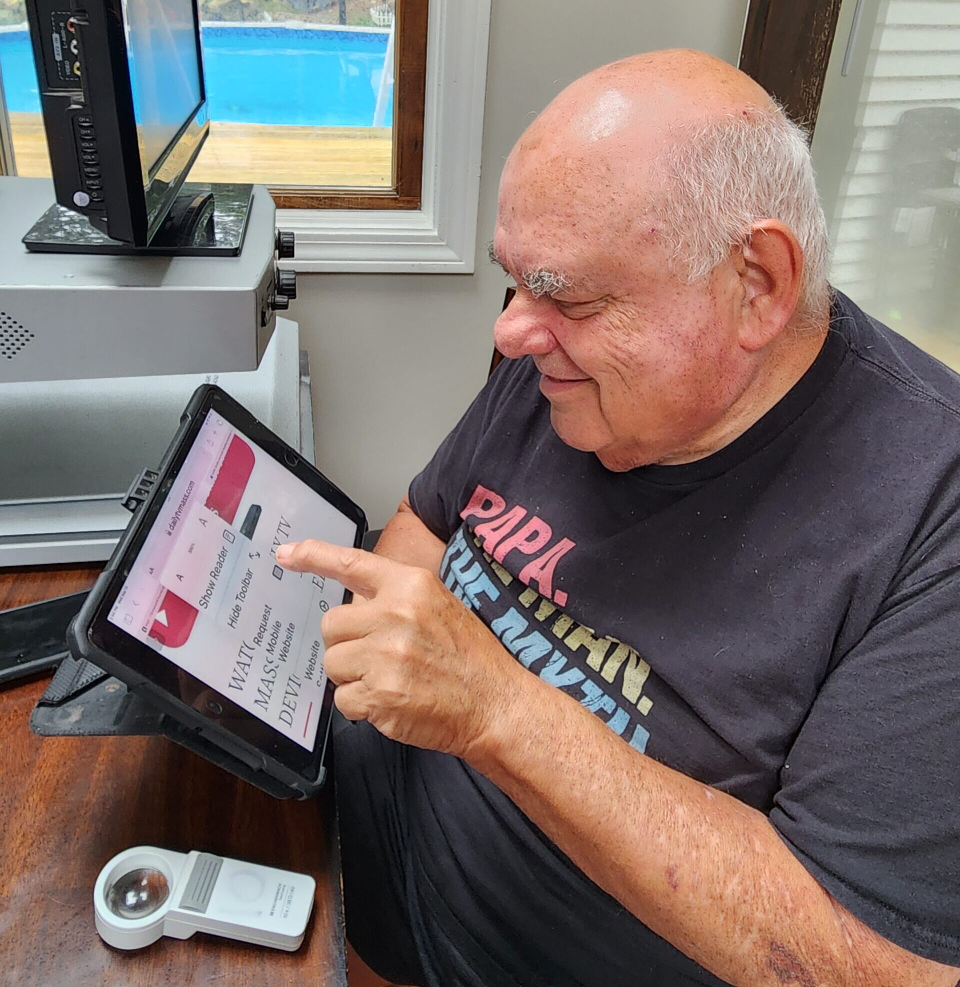 A senior man uses a tablet.