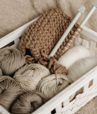 A basket full of yarn and a knitting project.