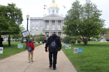Dave and James, carrying the sign, walking toward the State House.