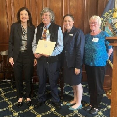 Joe holding up his award with Governor Kelly Ayotte by his side.