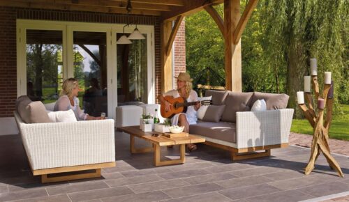 Two people lounging outside on patio furniture.