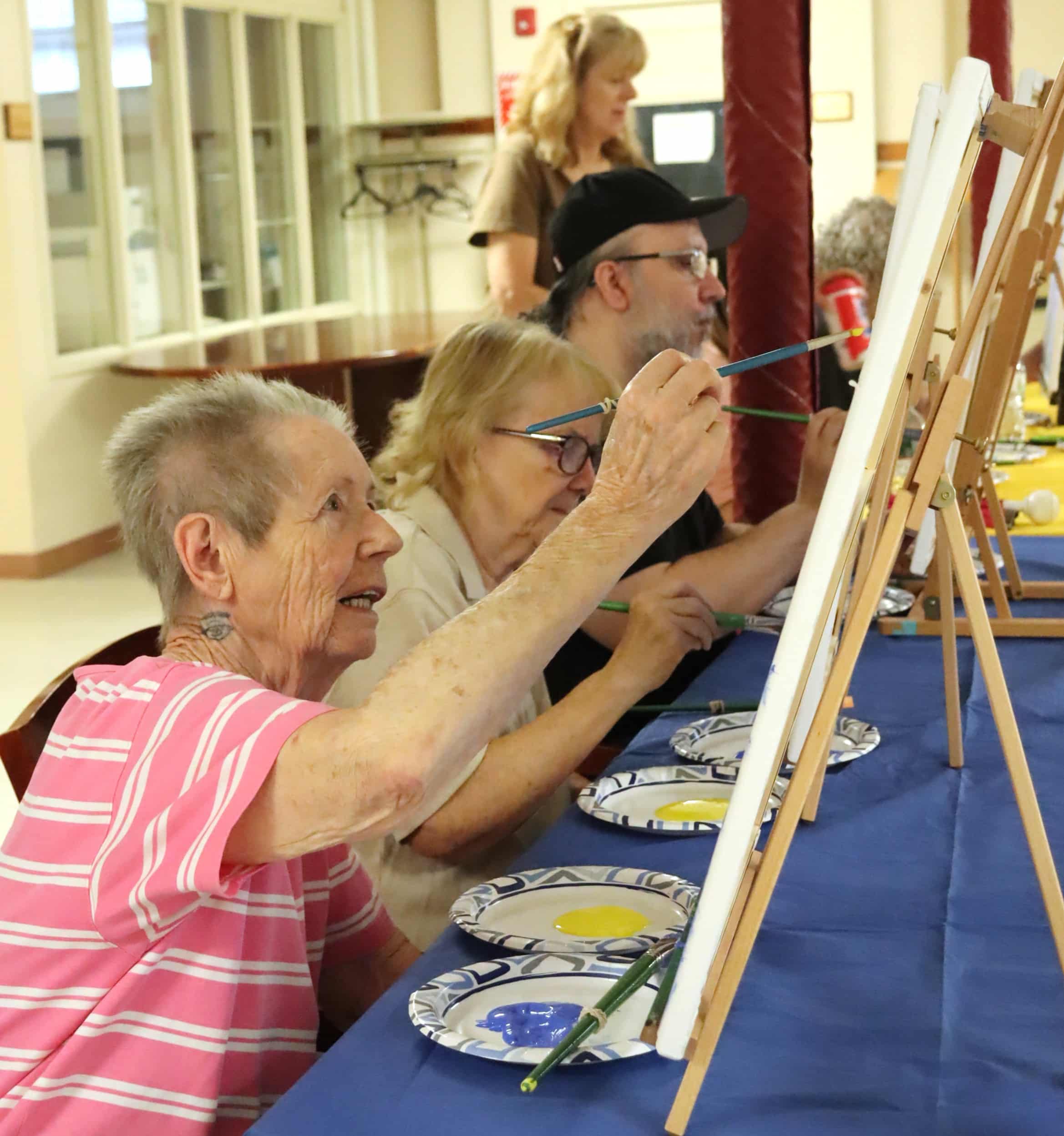A group of individuals painting canvases.