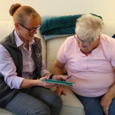A Future In Sight staff member helps a senior with technology.