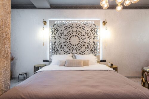 A neatly made bed with a decorative headboard.